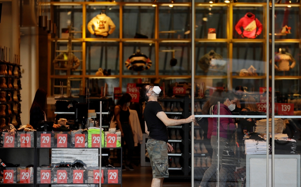 An employee opens doors of a clothing store on a first day of the re-opening of retail stores, amid the coronavirus disease (COVID-19) pandemic in Prague, Czech Republic, May 10, 2021. REUTERS/David W Cerny