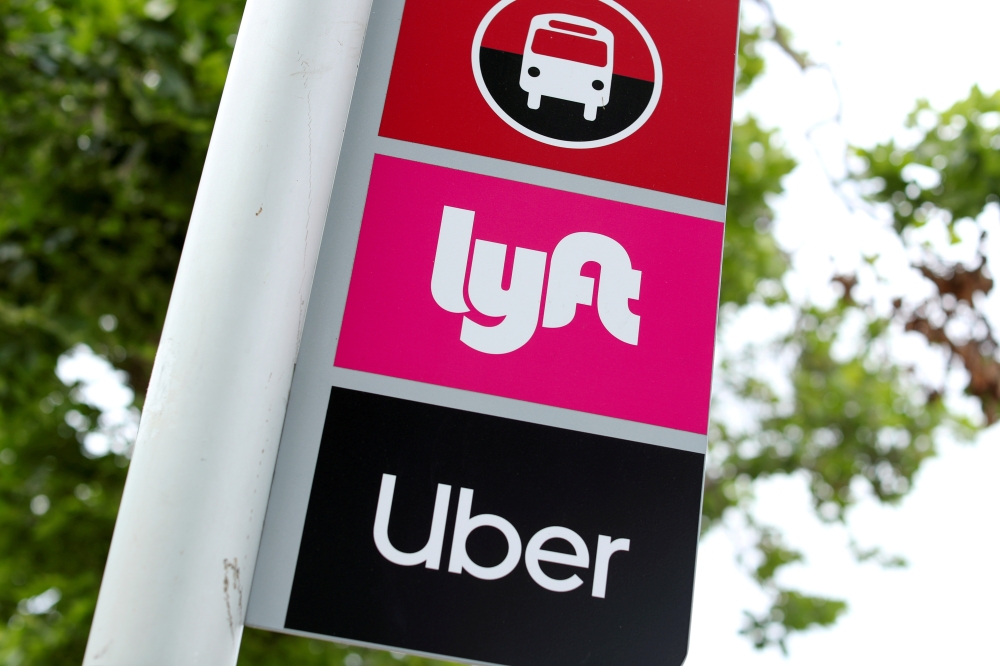 A sign marks a rendezvous location for Lyft and Uber users at San Diego State University in San Diego, California, U.S., May 13, 2020. REUTERS/Mike Blake/File Photo