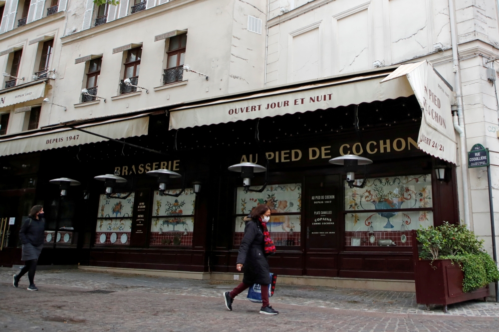 FILE PHOTO: People, wearing protective face masks, walk past a closed restaurant in Paris amid the coronavirus disease (COVID-19) outbreak in France, May 6, 2021. REUTERS/Sarah Meyssonnier