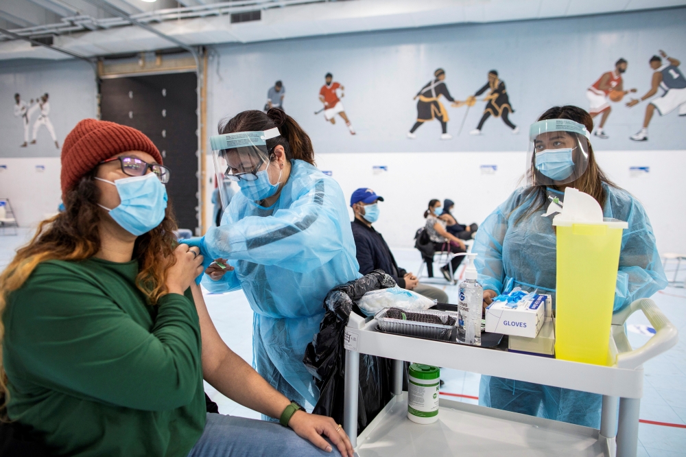 FILE PHOTO: Healthcare workers from Switch Health administer the Pfizer/BioNTech COVID-19 vaccine at the Ontario Khalsa Darbar pop-up vaccination clinic, set up with support from Amazon Canada, at the Sikh Gurudwara in Mississauga, Ontario, Canada May 4, 