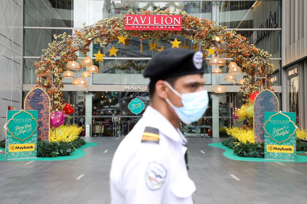 A security guard stands guard outside a closed mall during a lockdown due to the coronavirus disease (COVID-19) pandemic, in Kuala Lumpur, Malaysia, May 11, 2021. REUTERS/Lim Huey Teng/File Photo