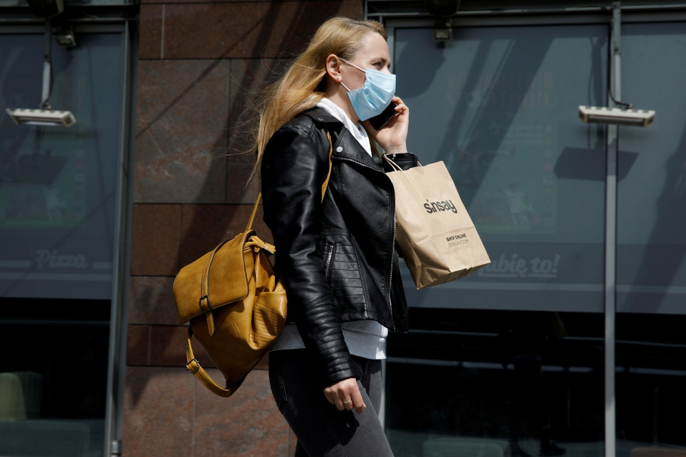  A woman wearing a protective mask walks in front of the Zlote Tarasy shopping mall in the centre of the city as the government eased coronavirus disease (COVID-19) restrictions, in Warsaw, Poland May 4, 2021. REUTERS/Kacper Pempel/File Photo