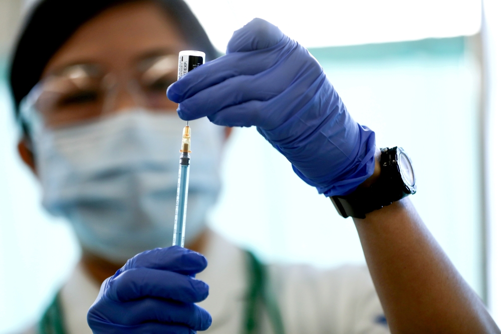File photo: A medical worker fills a syringe with a dose of the Pfizer-BioNTech coronavirus disease (COVID-19) vaccine, at Tokyo Medical Center in Tokyo, Japan February 17, 2021. Behrouz Mehri/Pool via Reuters/File Photo