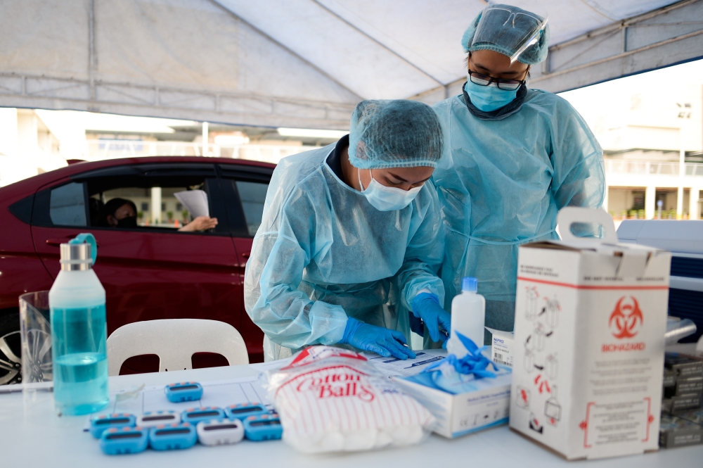 Health workers sort documents before administering the coronavirus disease (COVID-19) vaccine at a drive-thru vaccination site for bedridden and persons with disabilities, in Makati city, Metro Manila, Philippines, May 7, 2021. REUTERS/Lisa Marie David