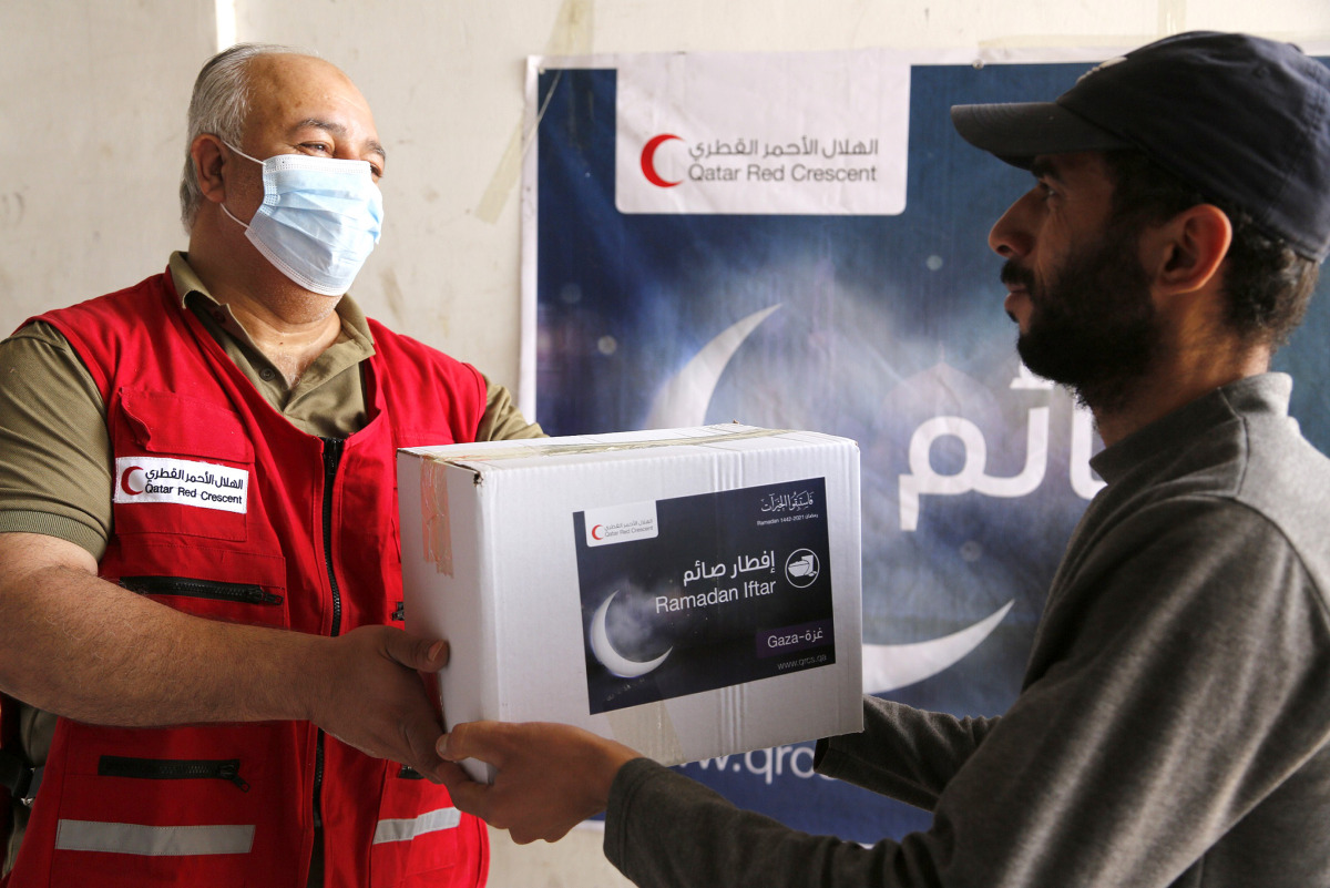 A Qatar Red Crescent Society representative handing over a food parcel to a beneficiary in Gaza.