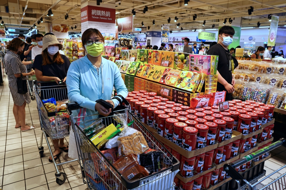 People wait to pay for their groceries after the government advised people to reduce leaving their homes and limit gatherings due to an increasing number of locally transmitted COVID-19 infections, in Taipei, Taiwan, May 15, 2021. Reuters/Ann Wang