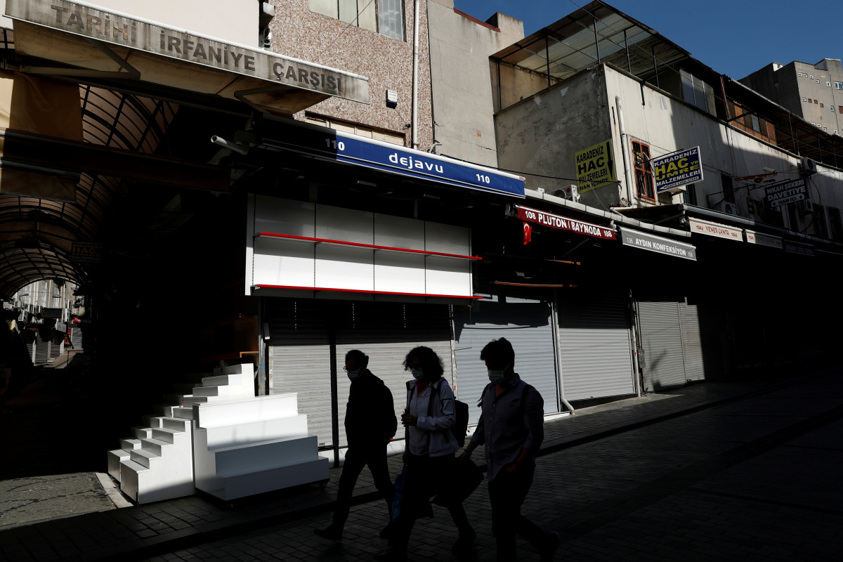 FILE PHOTO: People walk past by closed shops at deserted Mahmutpasa street, a popular middle-class shopping district, during a nationwide 