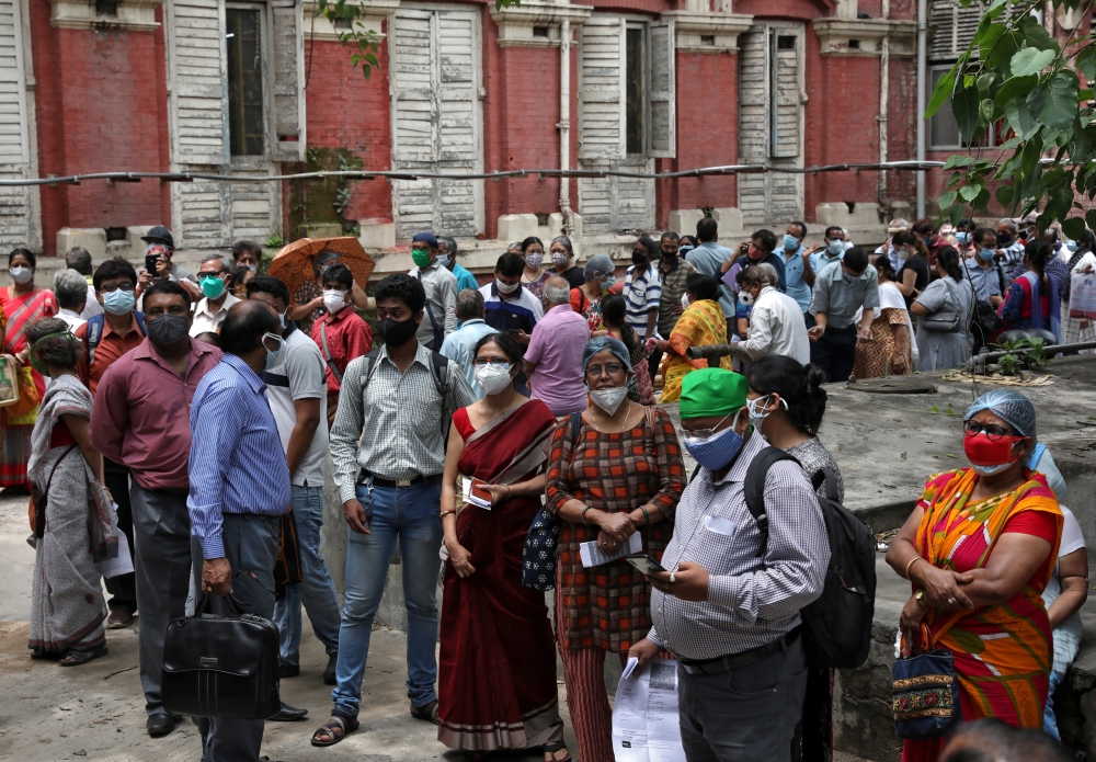 File photo: People wearing protective face masks wait to receive their second dose of COVISHIELD, a coronavirus disease (COVID-19) vaccine manufactured by Serum Institute of India, outside a vaccination centre in Kolkata, India, May 12, 2021. Reuters/Rupa