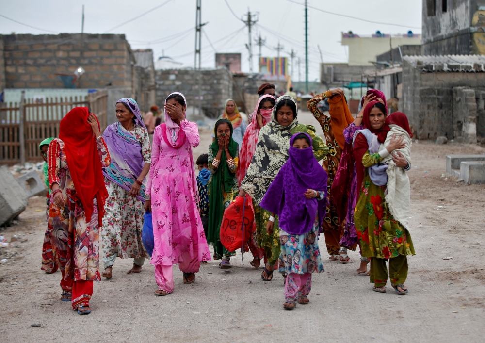 Women with their children leave their houses and evacuate to a safer place ahead of Cyclone Tauktae in Veraval in the western state of Gujarat, India, May 17, 2021. Reuters/Amit Dave