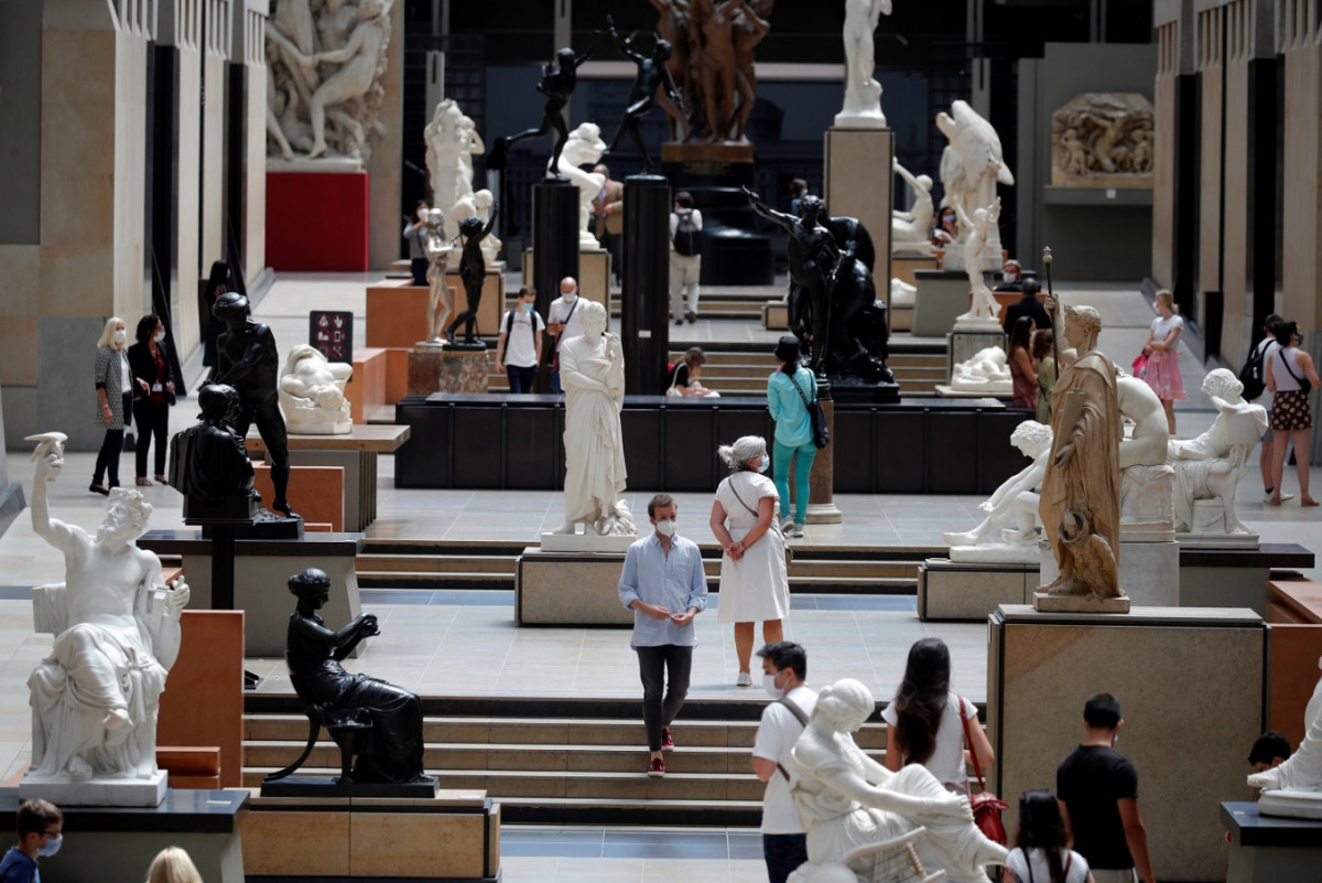 FILE PHOTO: Visitors, wearing protective face masks, look at artworks during a visit at the Musee d'Orsay, the former Gare d'Orsay train station, in Paris as the museum re-opens doors to the public following the coronavirus disease (COVID-19) outbreak in 