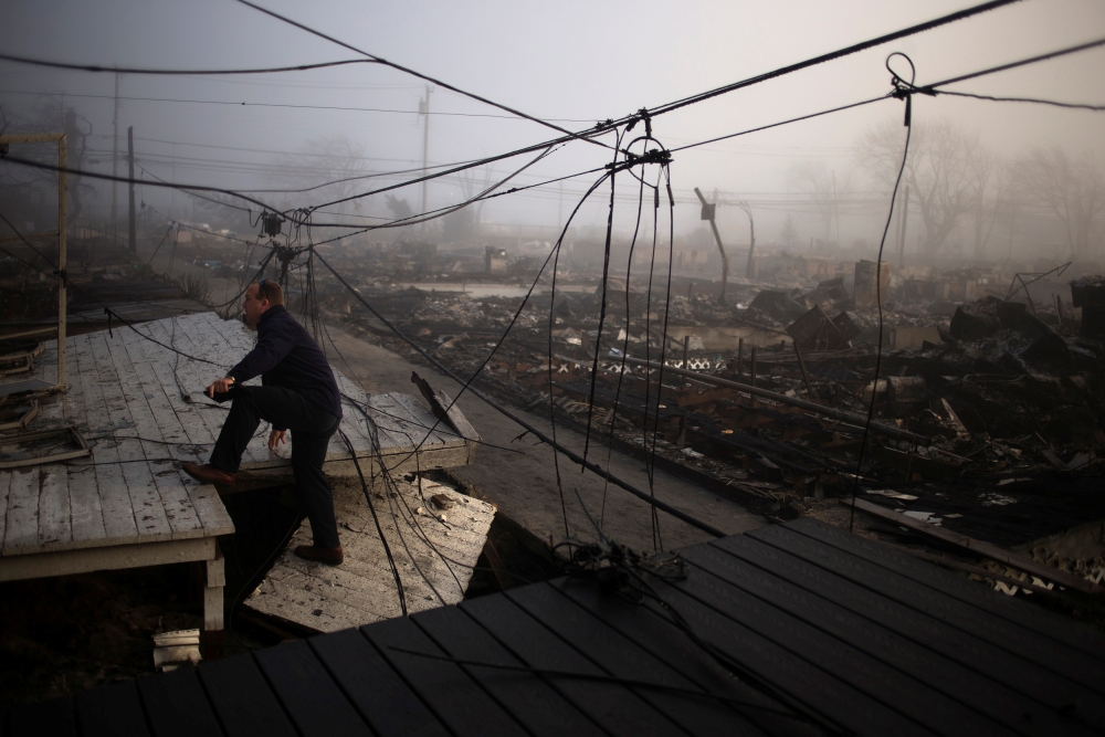 FILE PHOTO: An insurance claims adjuster climbs the entrance to a house in the Breezy Point neighborhood which was left devastated by Hurricane Sandy in the New York borough of Queens November 12, 2012. REUTERS/Adrees Latif/File Photo
