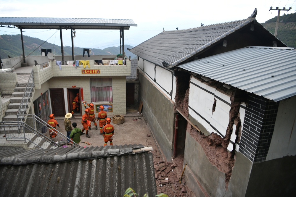 Rescue workers help transfer belongings from a damaged house following an earthquake in Yangbi county, Dali prefecture, Yunnan province, China May 22, 2021.