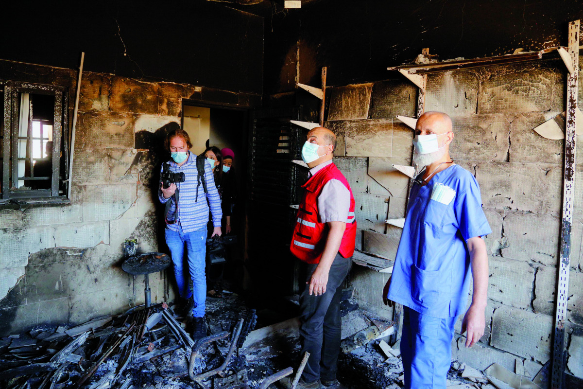A representative of QRCS at a house damaged in bombing in Gaza.