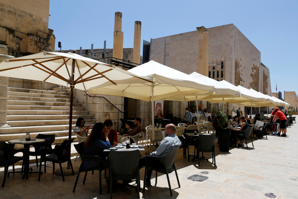 FILE PHOTO: People sit at an outdoor restaurant as restaurants and markets reopened for business after coronavirus disease (COVID-19) vaccinations reached 60% of the adult population, in Valletta, Malta May 10, 2021. REUTERS/Darrin Zammit Lupi/File Photo
