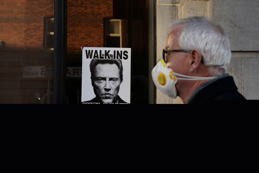 A man wearing a face mask walks past a restaurant in Dublin, Ireland. Reuters/File photo