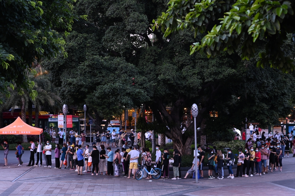 People line up to test for the coronavirus disease (COVID-19) at a makeshift nucleic acid testing site on Haizhu Square in Guangzhou, Guangdong province, China May 27, 2021. cnsphoto via Reuters 