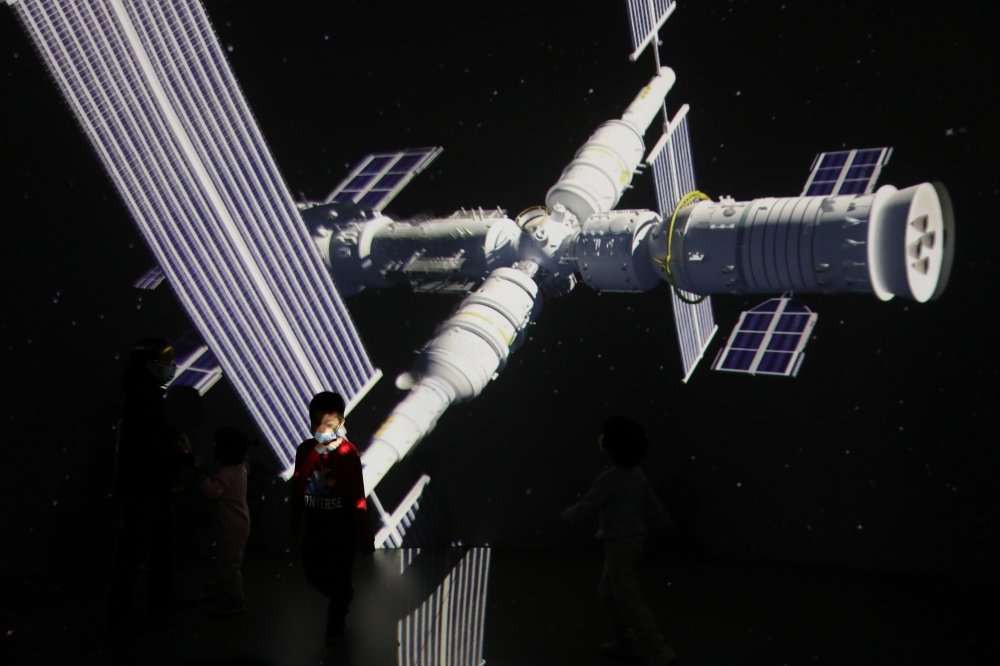 A child stands near a giant screen showing the images of the Tianhe space station at an exhibition featuring the development of China's space exploration on the country's Space Day at China Science and Technology Museum in Beijing. (Reuters/File Photo)