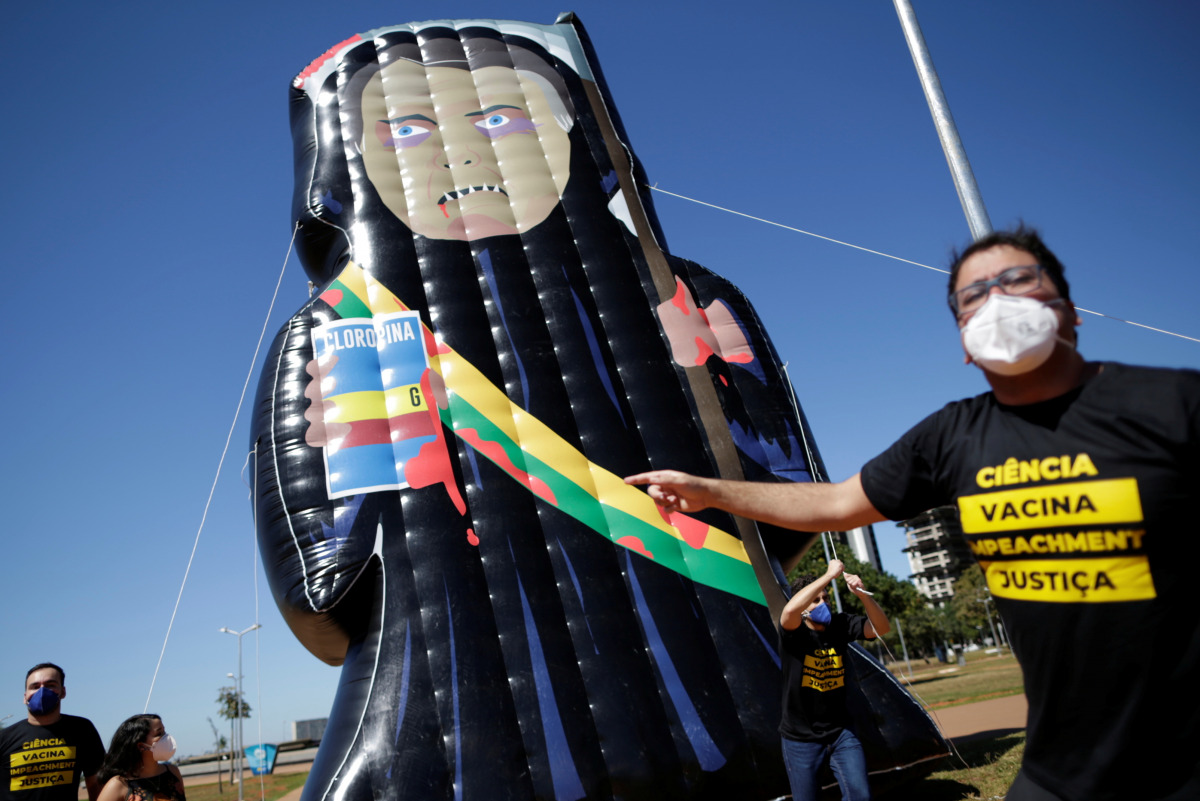 Demonstrators of the social movement Acredito, hold an inflatable doll known as 