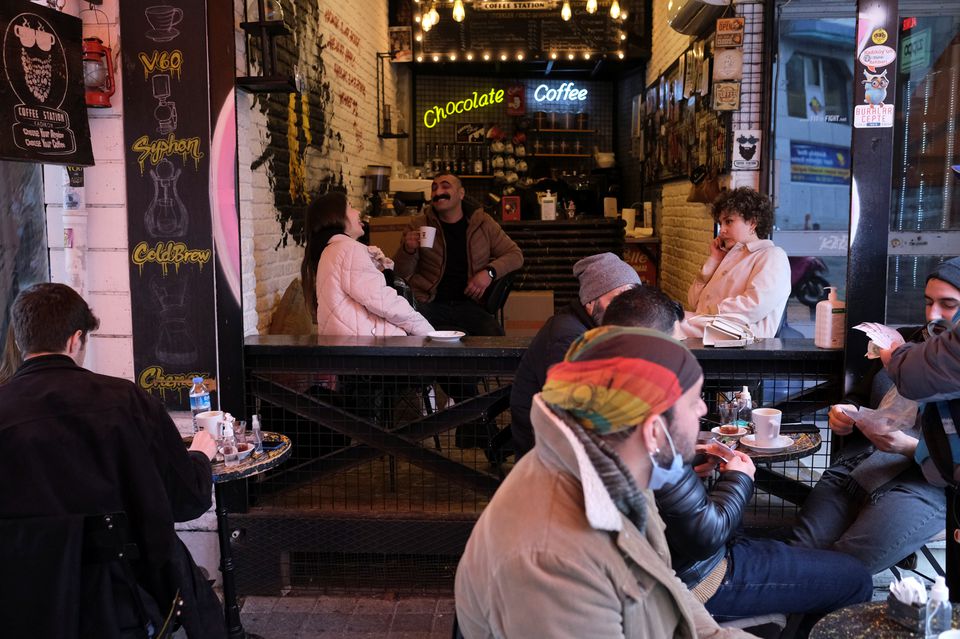 FILE PHOTO: People sit at a cafe that reopened after the coronavirus disease (COVID-19) restrictions were eased, in Istanbul, Turkey March 2, 2021. REUTERS/Cansu Alkaya


