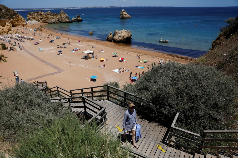 A person leaves Dona Ana beach in Lagos, Portugal, June 3, 2021. REUTERS/Pedro Nunes