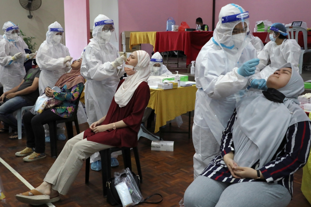 Medical workers collect swab samples from people to be tested for the coronavirus disease (COVID-19) in Cyberjaya, Malaysia, June 2, 2021. REUTERS/Lim Huey Teng
