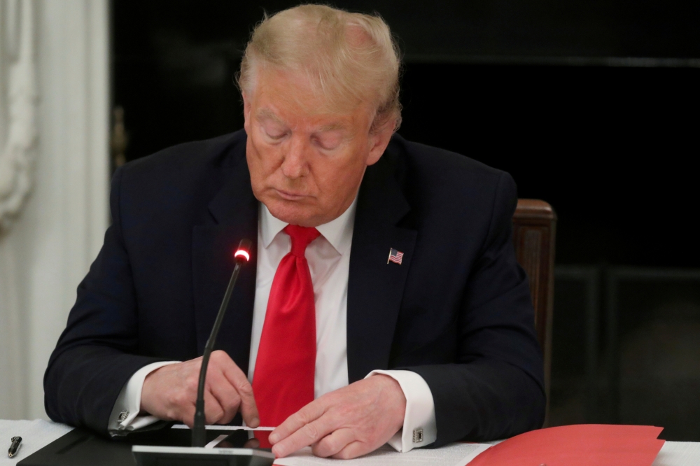 File photo: US President Donald Trump is seen tapping the screen on a mobile phone at the White House in Washington, US, June 18, 2020. Reuters/Leah Millis/File Photo