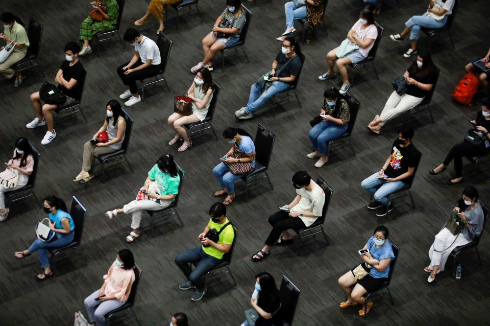 People wait to receive the first dose of the AstraZeneca COVID-19 vaccine against the coronavirus disease (COVID-19) as Thailand start a mass inoculation at a gymnasium inside the Siam paragon Shopping center, Bangkok, Thailand June 7, 2021. REUTERS/Soe Z