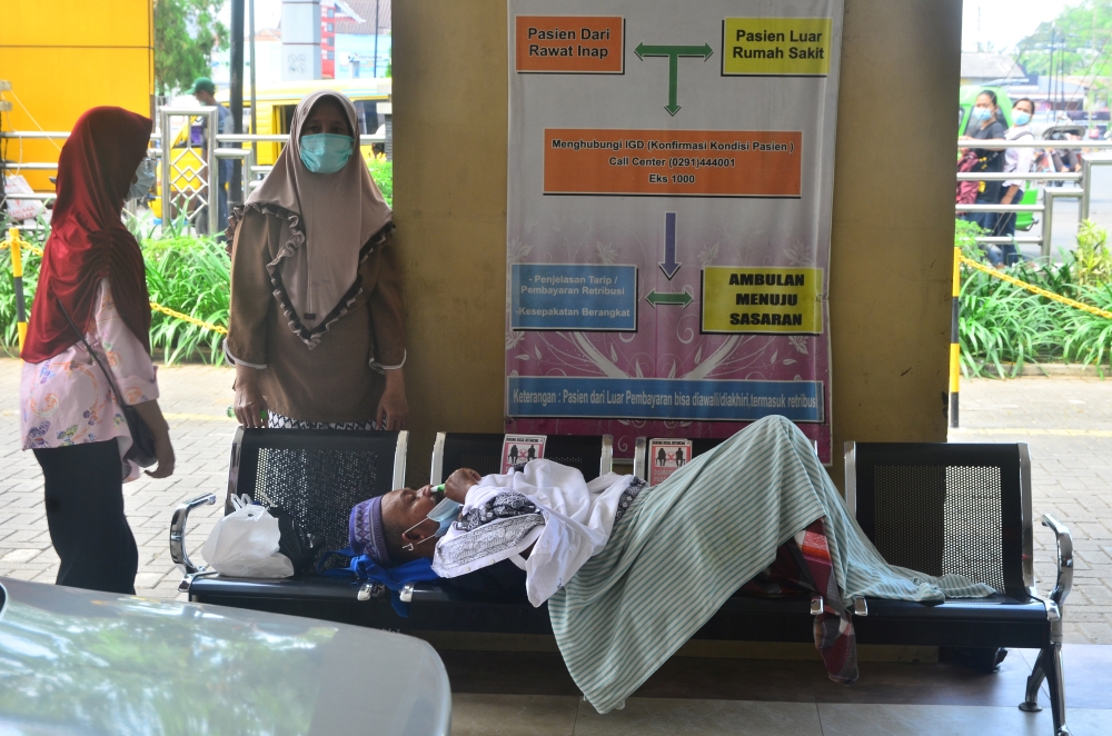 A patient lies on a bench while queuing to be treated at the emergency ward of the government's hospital Dr. Loekmono Hadi, amid the coronavirus disease (COVID-19) pandemic in Kudus, Central Java province, Indonesia, June 2, 2021. Picture taken June 2, 20