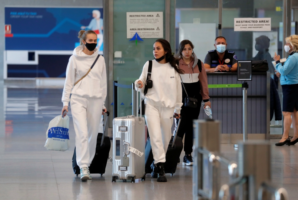 Tourists walk with their luggage as they arrive at Malaga-Costa del Sol Airport, in Malaga, Spain, June 7, 2021. REUTERS/Jon Nazca