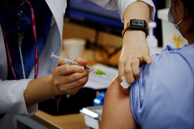 FILE PHOTO: A health worker gets a dose of the Pfizer-BioNTech coronavirus disease (COVID-19) vaccine at a COVID-19 vaccination center in Seoul, South Korea, March 10, 2021. REUTERS/Kim Hong-Ji/File Photo/File Photo