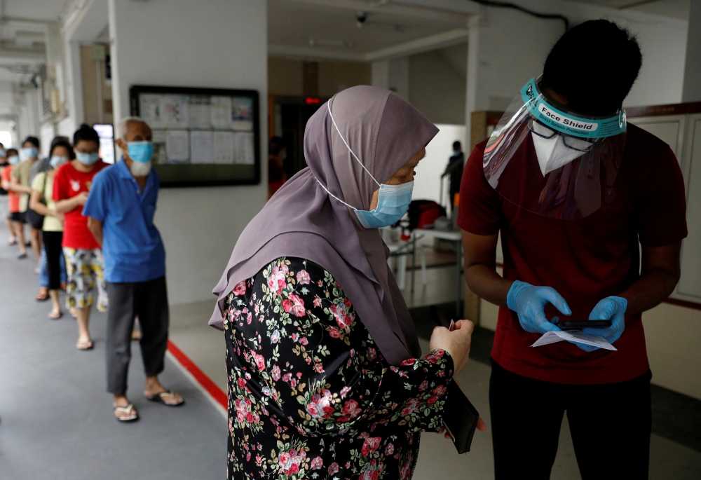 Residents of a public housing estate queue up for mandatory coronavirus disease (COVID-19) swab tests in Singapore May 21, 2021. REUTERS/Edgar Su/File Photo