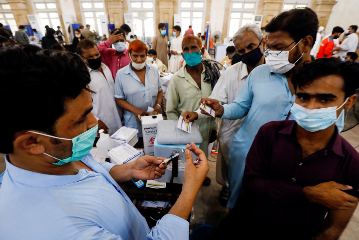Residents with their registration cards gather at a counter to receive a dose of coronavirus disease (COVID-19) vaccine at a vaccination center in Karachi, Pakistan June 9, 2021. REUTERS/Akhtar Soomro
