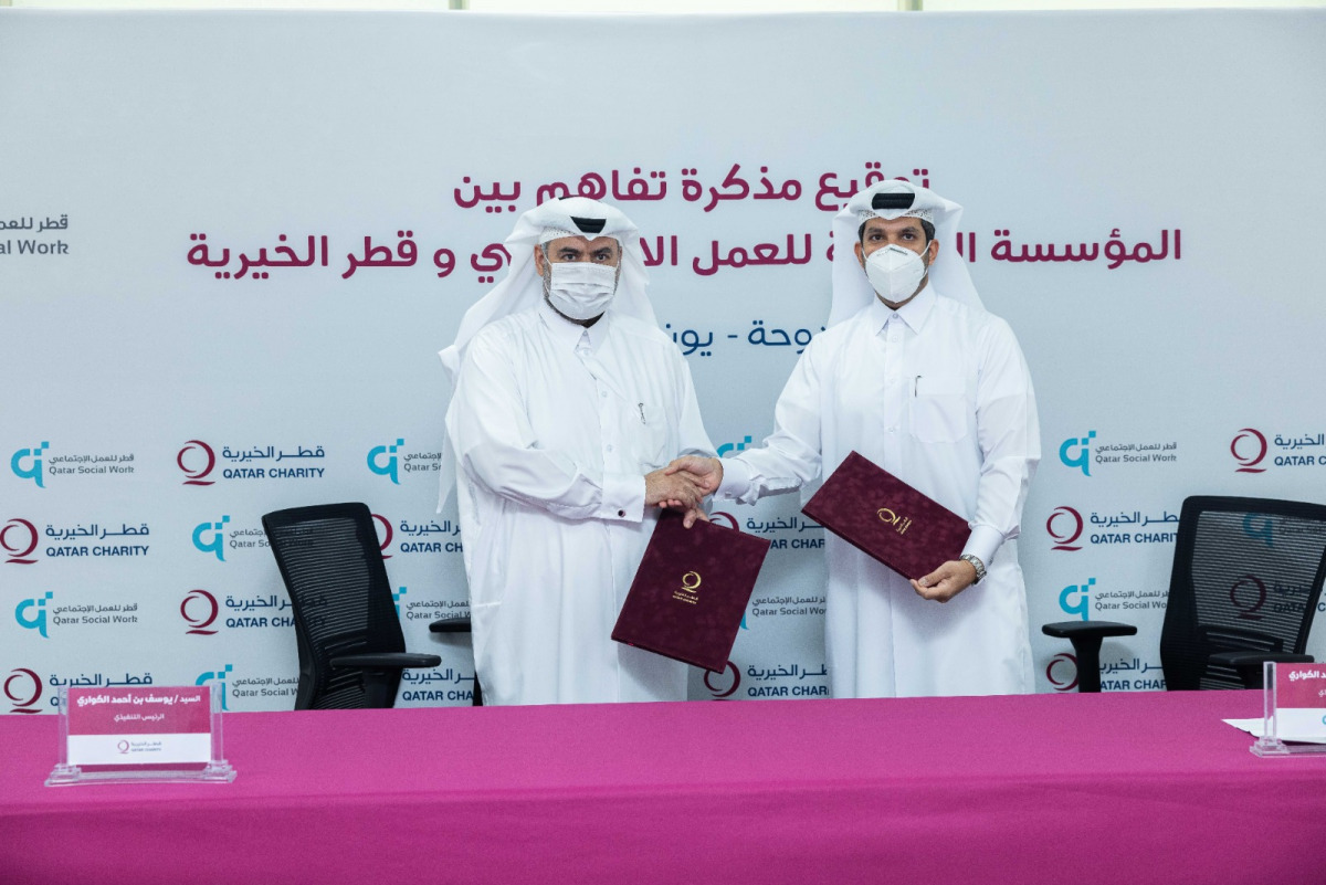 Yousef bin Ahmed Al Kuwari, CEO of Qatar Charity, and Ahmed bin Mohamed Al Kuwari, CEO of Qatar Foundation for Social Work, exchanging documents after signing the MoU.