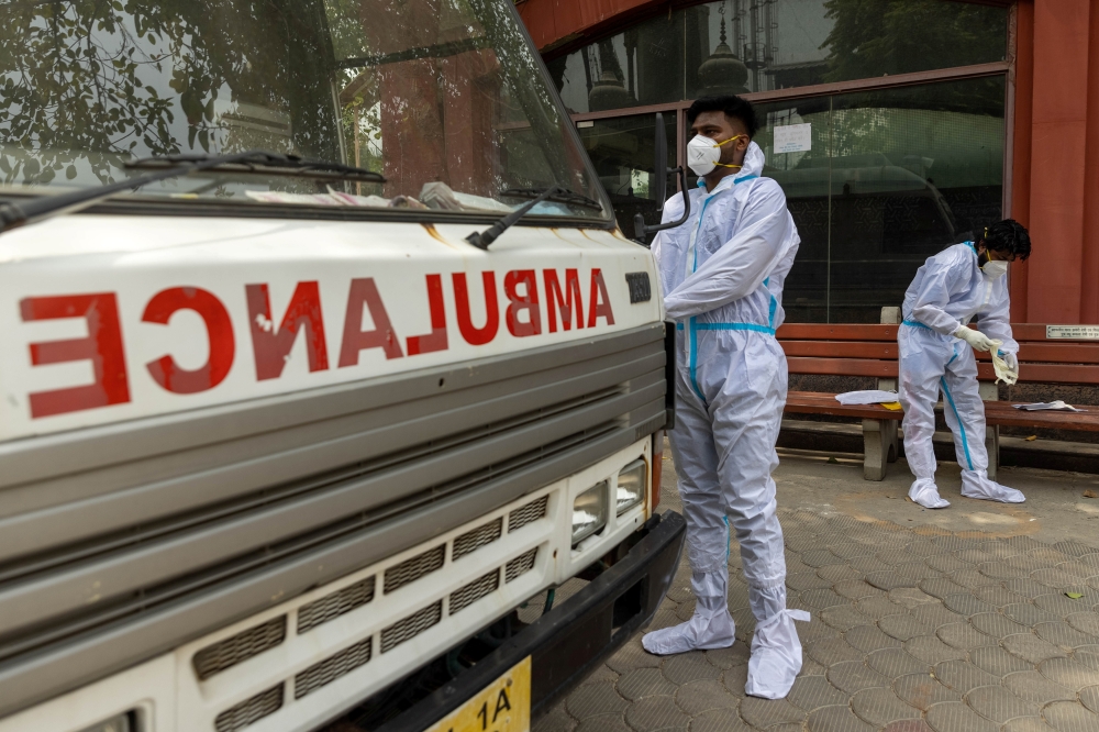 Health workers wear personal protective equipment (PPE) as they prepare to carry the body of a person, who died from complications related to the coronavirus disease (COVID-19), for cremation at a crematorium in New Delhi, India, June 10, 2021. REUTERS/Da