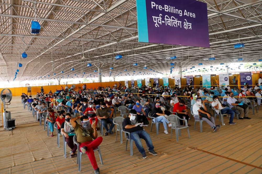 File photo: People wearing protective face masks wait to receive a dose of COVISHIELD, a coronavirus disease (COVID-19) vaccine manufactured by Serum Institute of India, at a vaccination centre in New Delhi, India, May 4, 2021. Reuters/Adnan Abidi/File Ph