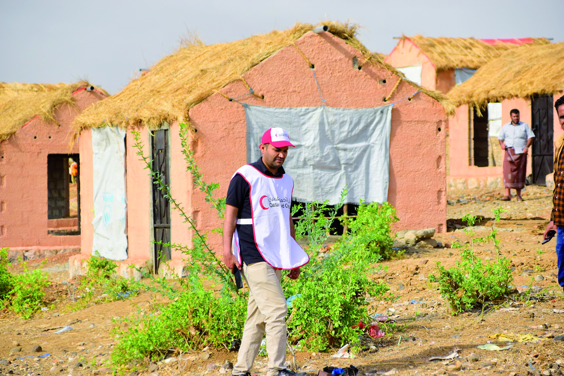 A QRCS representative handing over housing units to beneficiaries.