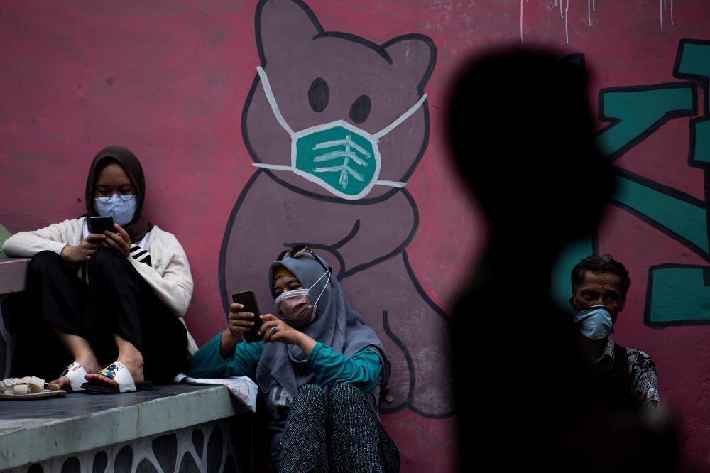 People wearing protective masks sit as they wait for their turn to receive vaccine in Jakarta, Indonesia June 11, 2021. Antara Foto/Sigid Kurniawan via Reuters
