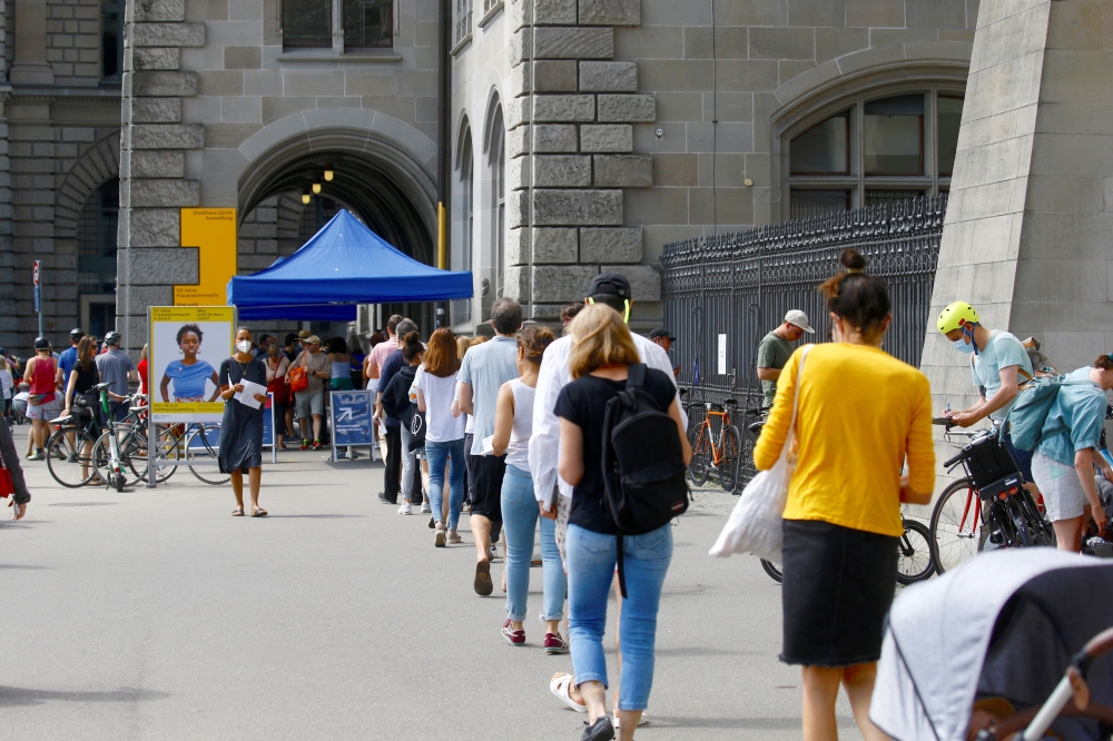 People queue to cast their votes in a series of referendums in front of a ballot station at the Stadthaus administration building in Zurich, Switzerland June 13, 2021. Reuters/Arnd Wiegmann