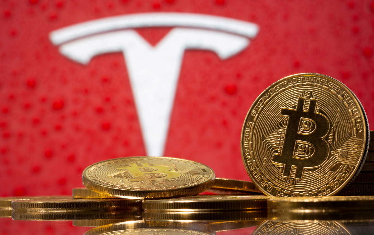 FILE PHOTO: Representations of virtual currency bitcoin are seen in front of Tesla logo in this illustration taken, February 9, 2021. REUTERS/Dado Ruvic/File Photo
