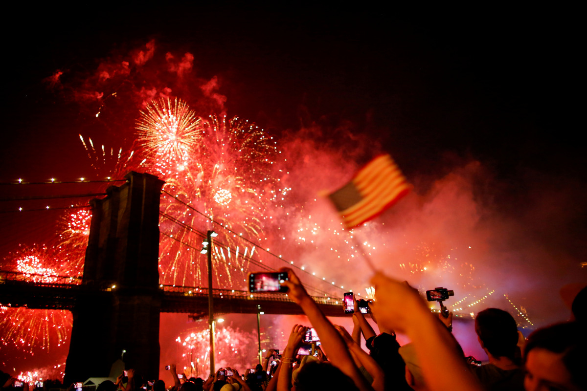 FILE PHOTO: People watch the Macy's 4th of July Firework Show over the Brooklyn Bridge in New York, U.S., July 4, 2019. REUTERS/Eduardo Munoz/File Photo
