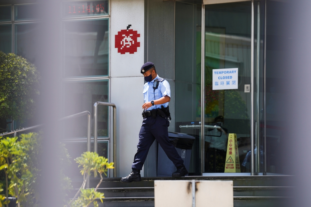 A police officer walks outside the headquarters of Apple Daily and Next Media after police arrested five Apple Daily executives who were suspected to have breached the new national security law, in Hong Kong, China June 17, 2021. Reuters/Lam Yik