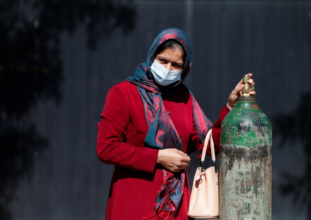 A woman waits outside a factory to get her oxygen cylinder refilled, amidst the spread of the coronavirus disease (COVID-19) in Kabul, Afghanistan on June 15, 2021. (REUTERS)