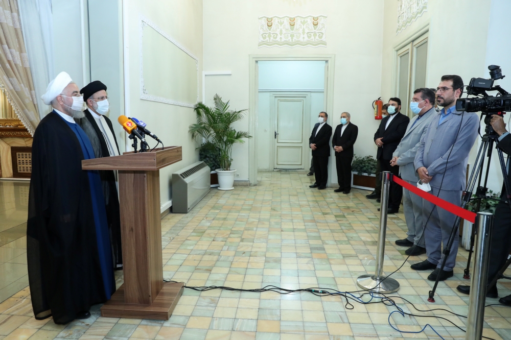 Iran's outgoing President Hassan Rouhani and Iran's President-elect Ebrahim Raisi speak to the media after their meeting in Tehran, Iran June 19, 2021. (Official Presidential website/Handout via REUTERS)