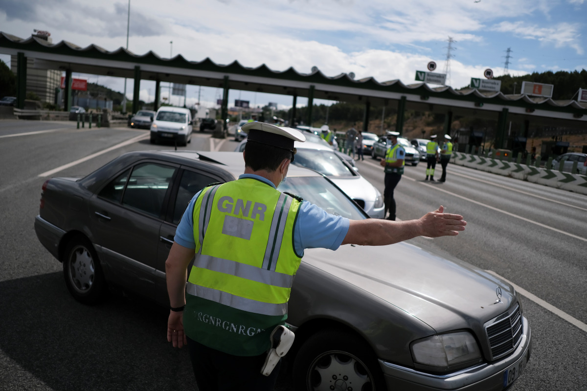 A police officer stops a car at a checkpoint for control to stop unauthorised travel during a two-day weekend from and to Lisbon's metropolitan area, to contain the spread of the coronavirus disease (COVID-19) as the number of cases rise, in Alverca, Port