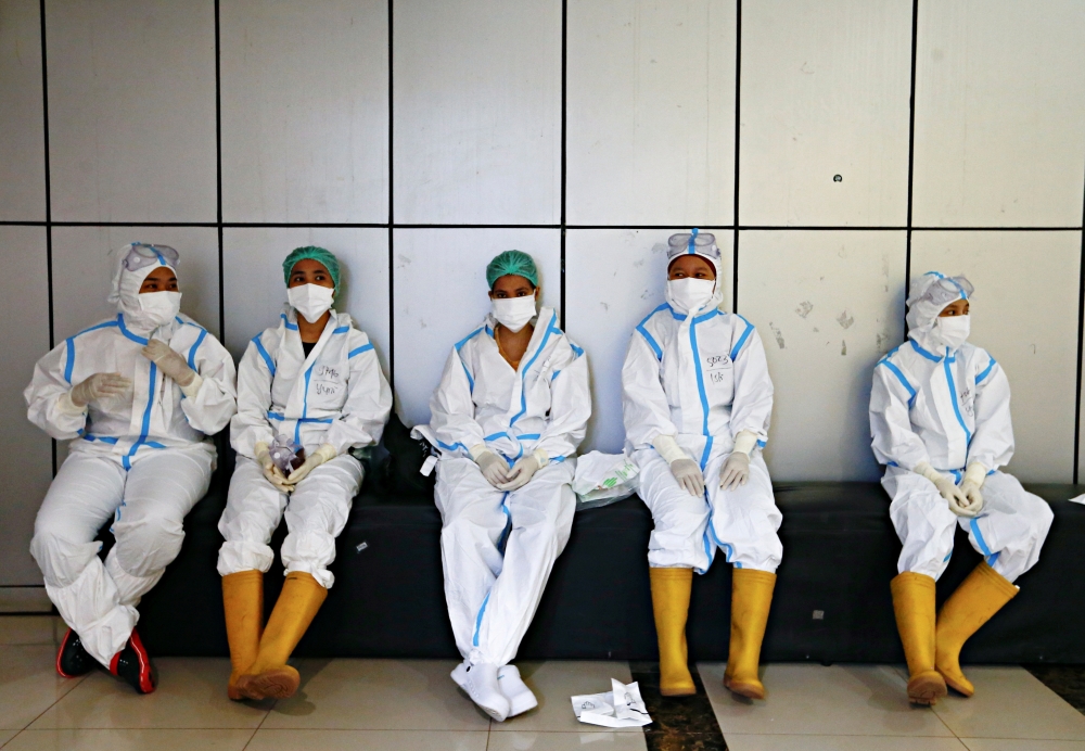 Healthcare workers wearing personal protective equipment (PPE) get ready to treat patients at the emergency hospital for the coronavirus disease (COVID-19), in Jakarta, Indonesia, June 17, 2021. REUTERS/Ajeng Dinar Ulfiana/File Photo