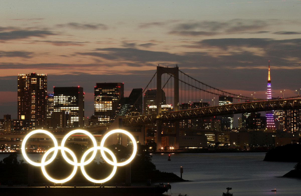 A general view of the Olympic Rings installed on a floating platform with the Rainbow Bridge in the background in preparation for the Tokyo 2020 Olympic Games in Tokyo, Japan June 21, 2021. Picture taken with long exposure. REUTERS/Pawel Kopczynski

