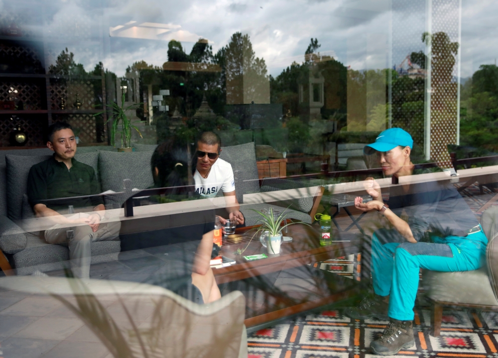 Chinese climbers who were stranded in Kathmandu due to coronavirus disease (COVID-19) restrictions on travel, sit inside a hotel lobby, Nepal June 17, 2021. Picture taken June 17, 2021. REUTERS/Navesh Chitrakar