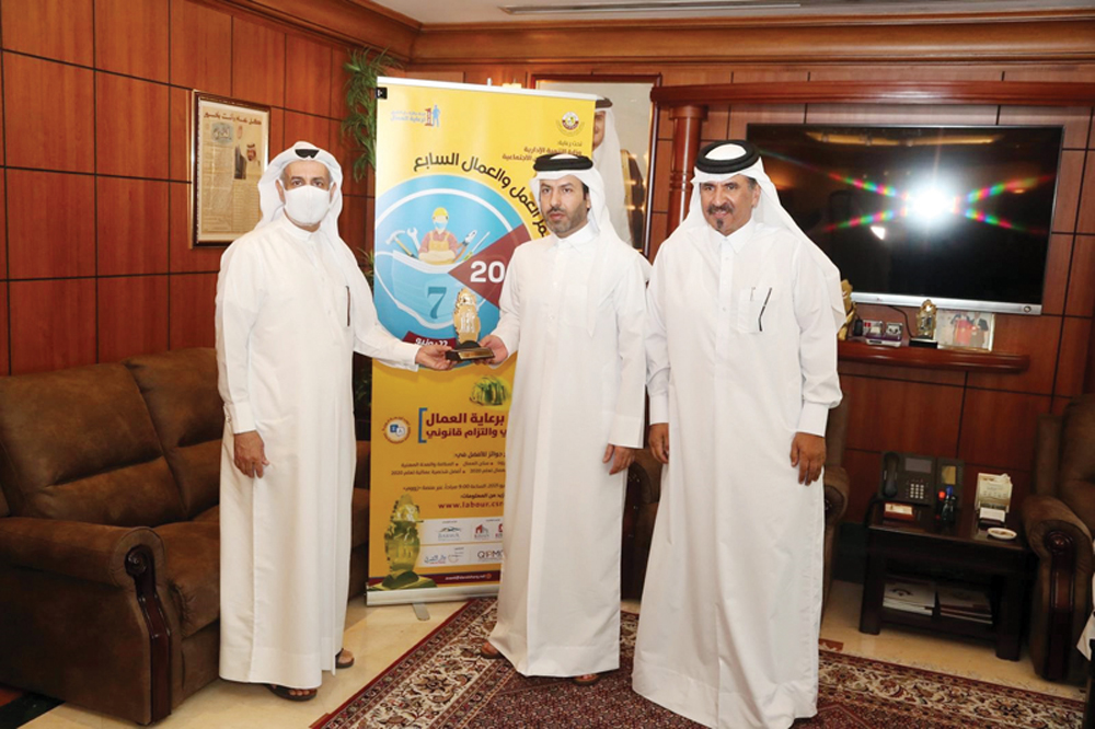 CEO of Dar Al Sharq Group, Abdul Latif Abdullah Al Mahmoud (left), and Chairman of the Workers’ Welfare Awards Committee, Mohamed bin Towar Al Kuwari (right), presenting an award to Director of Labour Inspection Department at MADLSA, Fahad Zafer Al Dosari