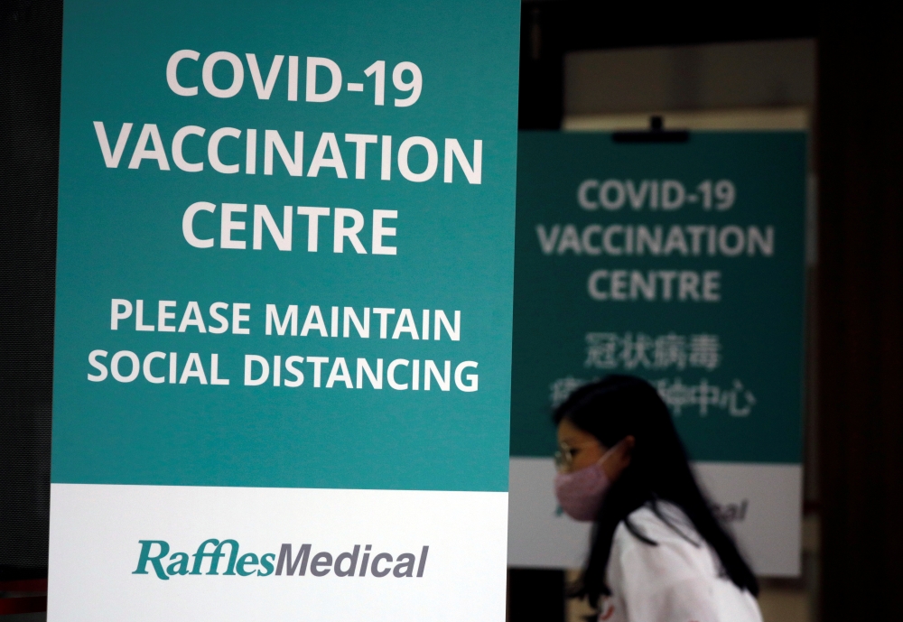 A woman walks into a newly set up coronavirus disease (COVID-19) vaccination center which will be opened to the public the day after, in Singapore January 26, 2021. REUTERS/Edgar Su/File Photo