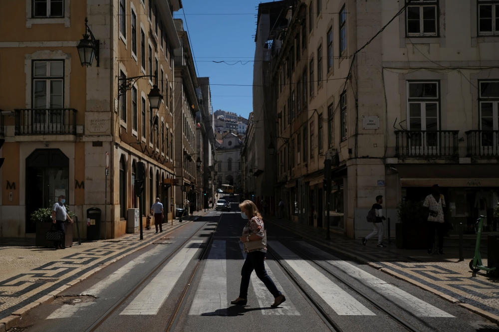 A person wearing a protective mask walks in Lisbon downtown amid the coronavirus disease (COVID-19) pandemic, in Lisbon, Portugal, June 24, 2021. REUTERS/Pedro Nunes